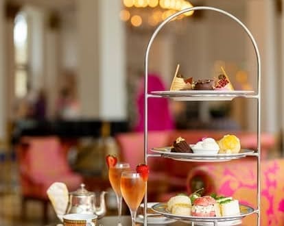 Elegant high tea setup with desserts and champagne.