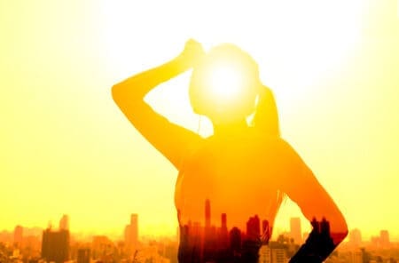Traveller shielding eyes under intense sunlight in the Philippines, highlighting extreme heat and heatstroke risk for tourists